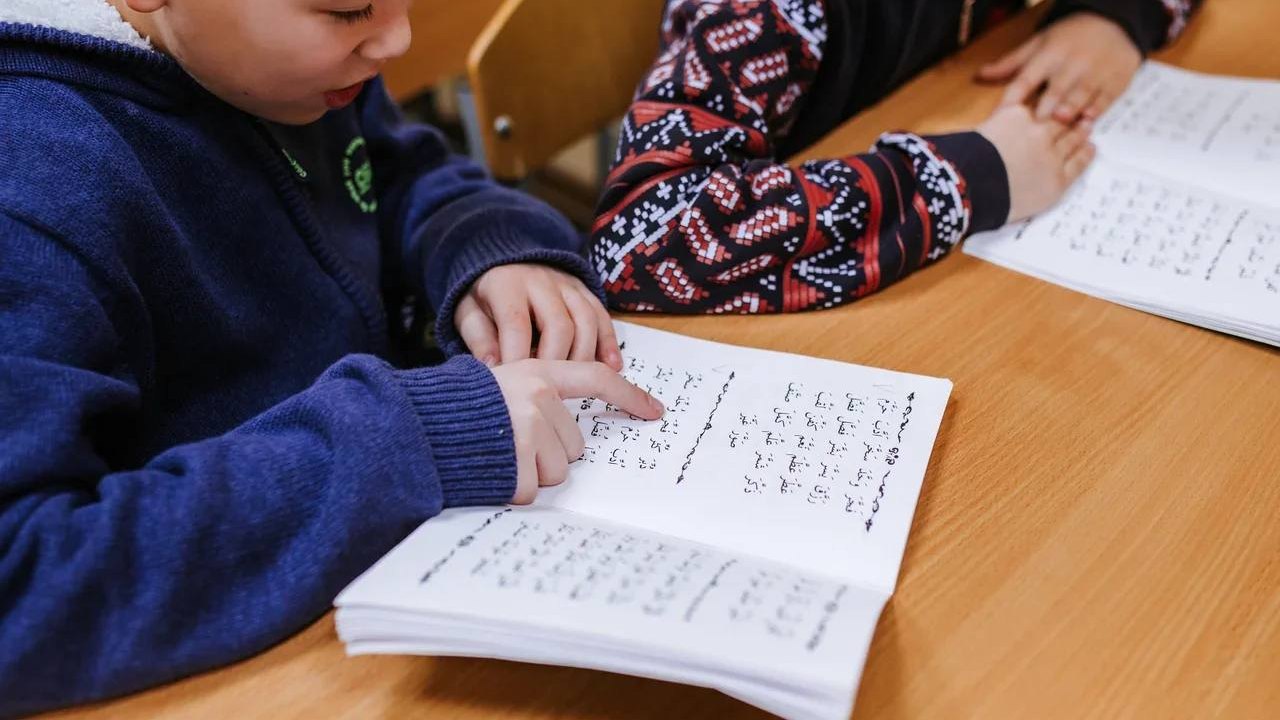 Ученик читает по учебнику таджвида